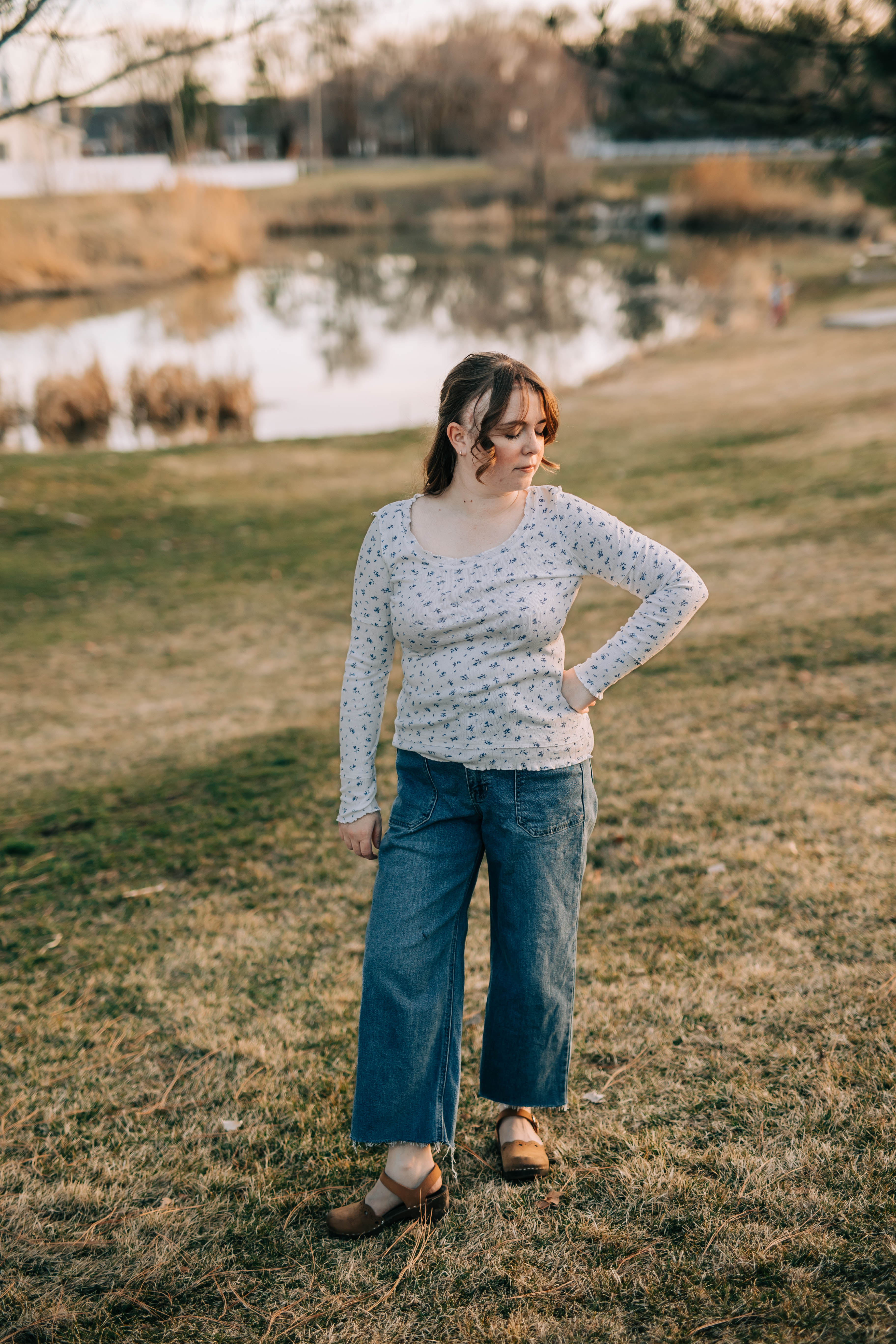 Model wearing the Chelsea top which is white with small blue flower. She is also wearing jeans and brown leather Mary janes. 